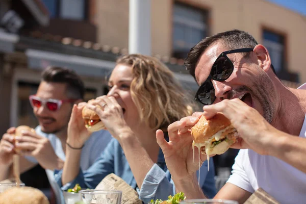 Drei Freunde Essen Burger Und Lächeln — Stockfoto