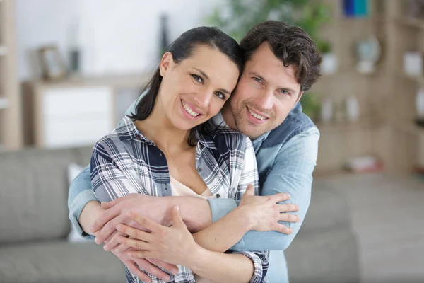 Loving Couple Hugging Sofa Looking Camera — Stock Photo, Image