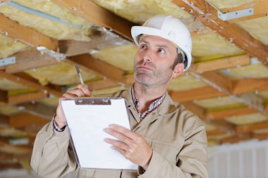 male inspector assessing property under renovation clipart