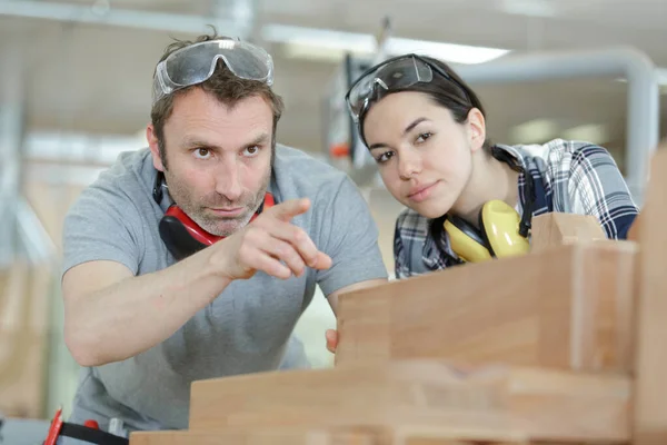 Pointing Male Carpenter Training Female Apprentice — Stock Photo, Image