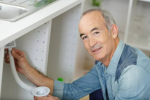 Anziano Che Lavora Tubi Sotto Lavello Della Cucina — Foto Stock