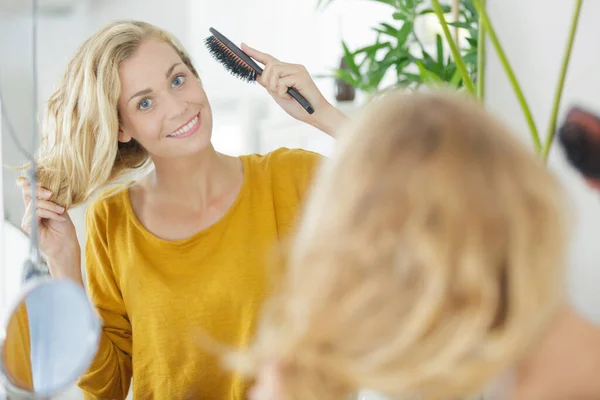 Jovem Mulher Escovando Cabelo Frente Espelho Banheiro — Fotografia de Stock