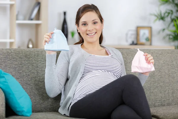 Attractive Pregnant Woman Holding Baby Hats — Stock Photo, Image