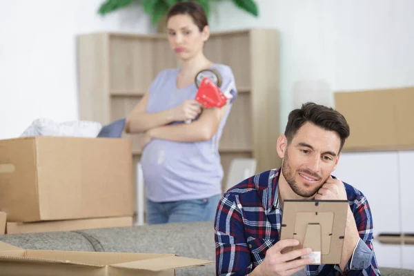 Mann Schaut Sich Bild Während Frau Auspackt — Stockfoto