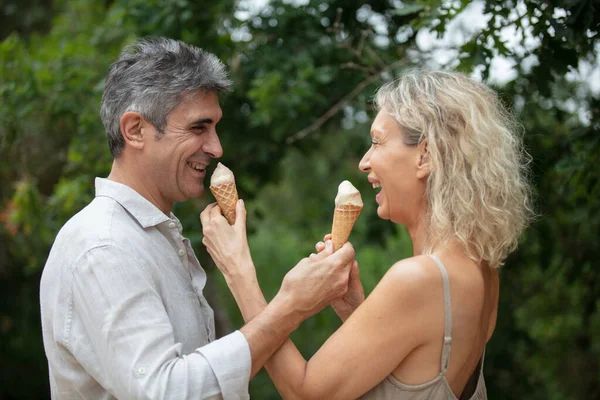 幸せなロマンチックな成熟した魅力的な中年のカップルはアイスクリームを楽しんでいます — ストック写真