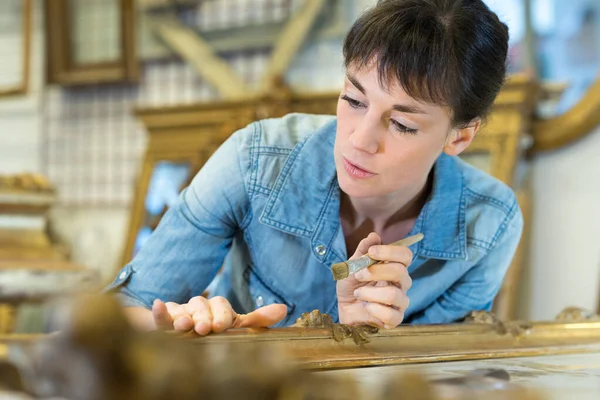 female workman in picture framing workshop