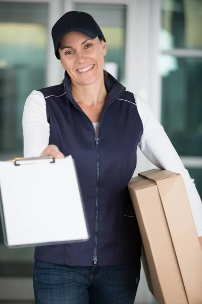 Female Courier Parcels Holding Clipboard Forward Signature — Stock Photo, Image