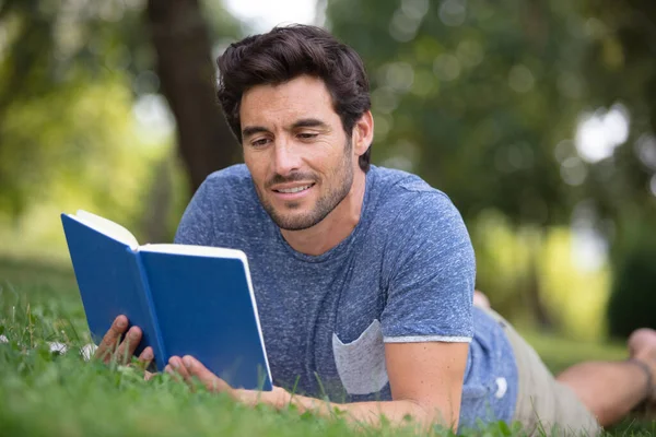 Hombre Leyendo Libro Sobre Hierba — Foto de Stock