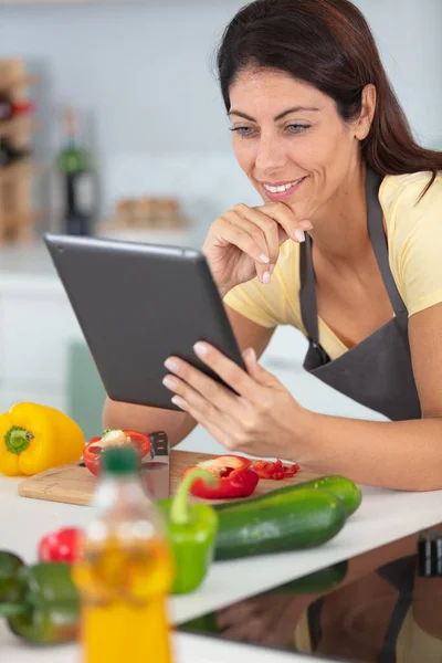 Frau Schaut Bei Gemüsezubereitung Auf Tablet — Stockfoto