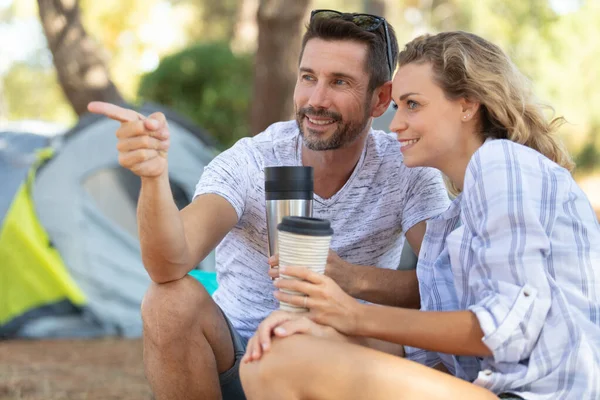 キャンプ場で魔法瓶を飲んでいる若いカップルが — ストック写真