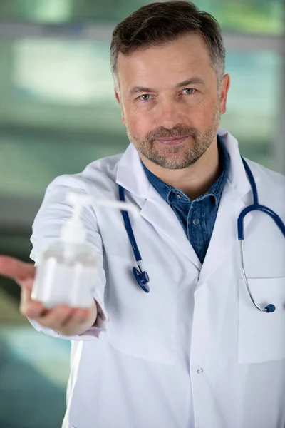 医生拿着一瓶消毒剂 — 图库照片