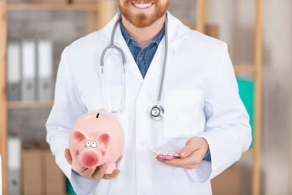 Male Doctor Holding Piggy Bank — Stock Photo, Image