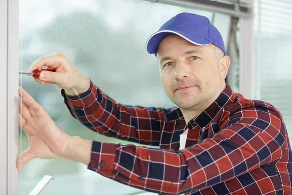 worker fasten the handle to a plastic window