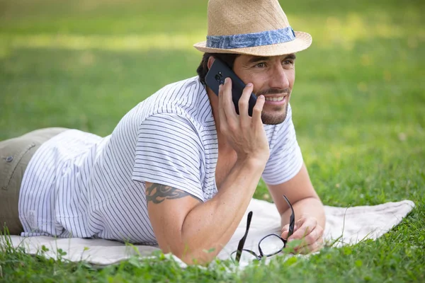 Uomo Posa Erba Nel Parco Parlando Smartphone — Foto Stock