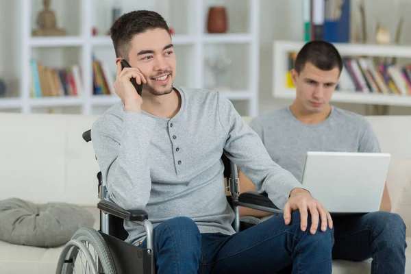 One Young Man Using Laptop Second Wheelchair Cellphone — Stock Photo, Image