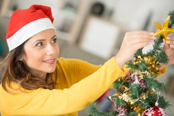 头戴毛衣装饰圣诞树的女人 — 图库照片