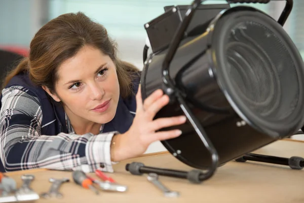 写真家のライトプロジェクターを修理する女性 — ストック写真