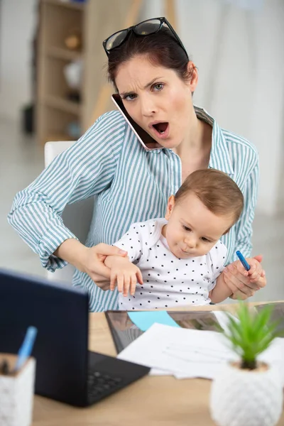 Zestresowana Pracująca Mama Dzieckiem Kolanach — Zdjęcie stockowe
