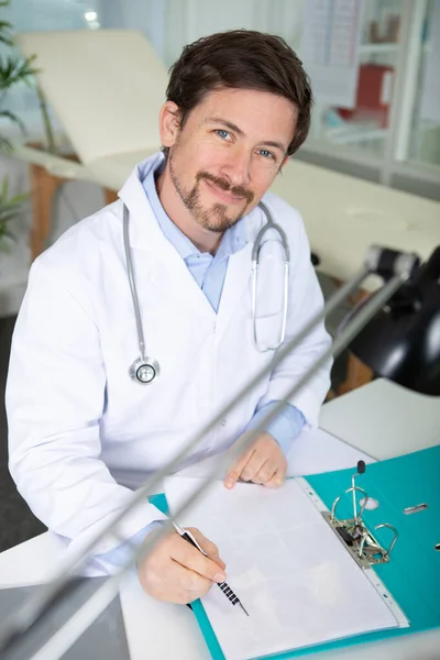 Médico Sonriente Con Una Carpeta Uniforme Pie Hospital — Foto de Stock