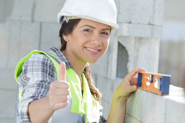 親指を立てた女性建設労働者は — ストック写真