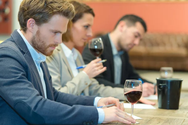 experts tasting new sorts of wine at the table