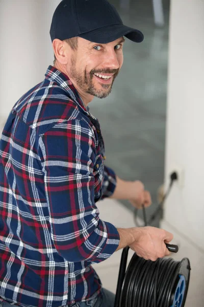 Szczęśliwy Mężczyzna Technik Trzyma Wtyczkę Elektryczną — Zdjęcie stockowe