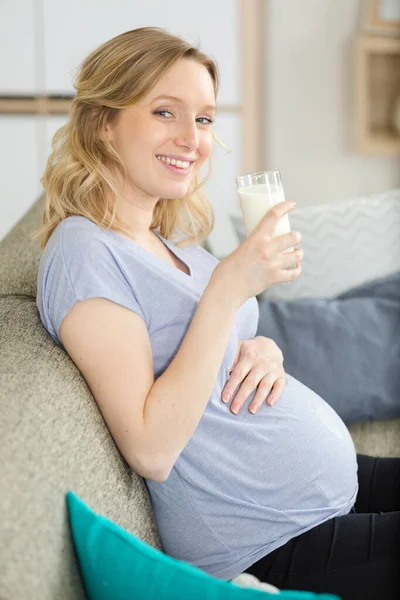 Junge Schwangere Frau Mit Milch Und Frühstück Auf Dem Sofa — Stockfoto
