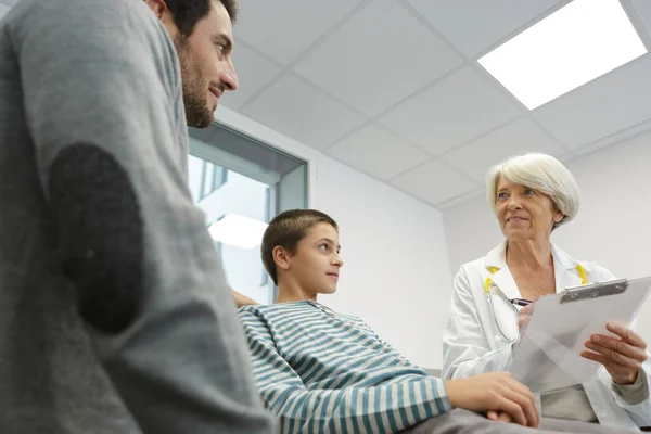 son and father looking at the doctor in hospital