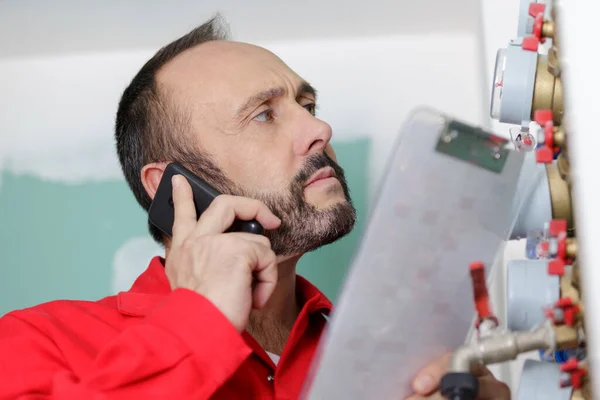 Klempner Telefon Beim Ablesen Des Wasserzählers — Stockfoto