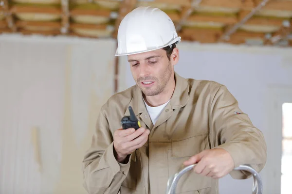 civil engineer wearing safety helmet using radio walkie talkie