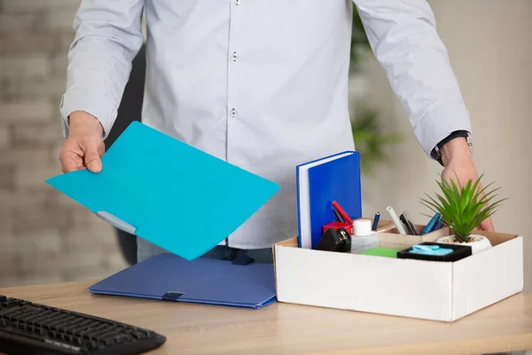 young man with box of stuff in office closeup