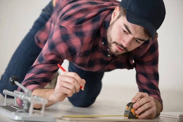 Hombre Que Mide Una Baldosa Mientras Que Pone Nuevo Suelo — Foto de Stock