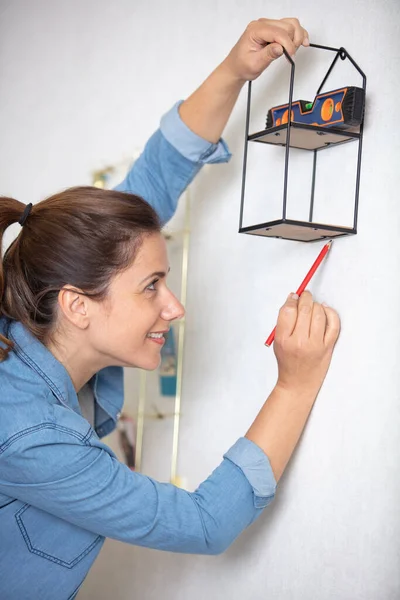 Woman Hanging Shelf Wall Decorating Flat Space — Stockfoto