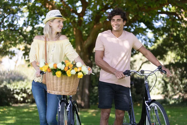 Attraente Coppia Spingendo Biciclette Con Fiori Nel Cestino — Foto Stock