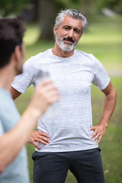 portrait of joyful active retired man with son