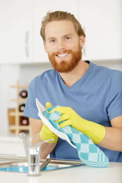Ένας Ευτυχισμένος Άντρας Πλένει Πιάτα — Φωτογραφία Αρχείου