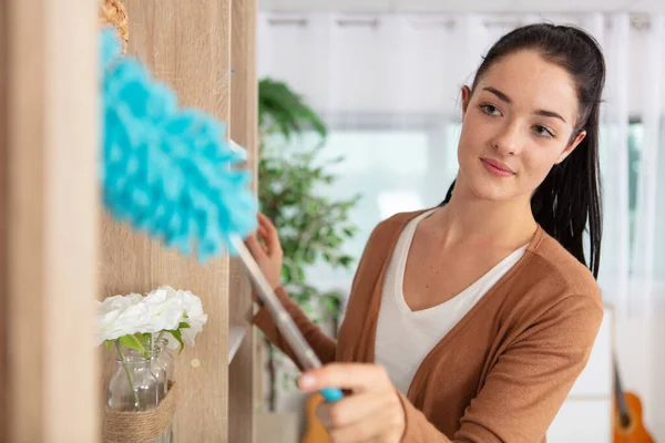 Lovely Young Woman Dusting Shelf Home — Stock Photo, Image