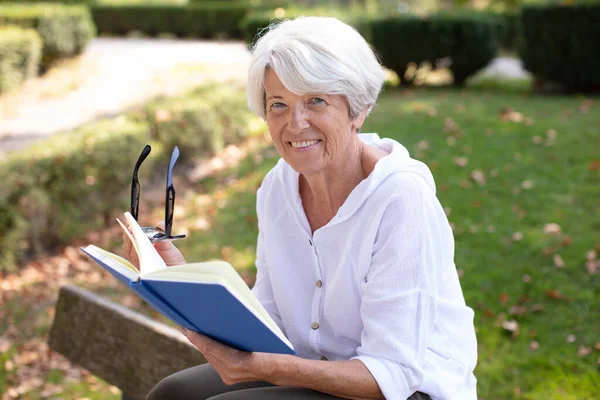 Šťastná Starší Žena Čtení Knihy Venku — Stock fotografie