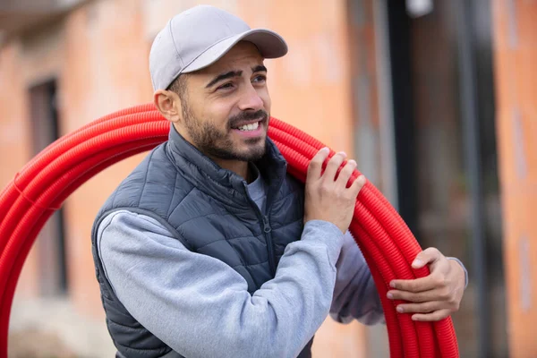 Constructor Masculino Llevando Carrete Tubo Rojo Hombro — Foto de Stock