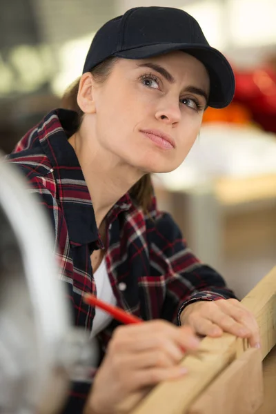 Female Carpenter Marking Wood Plank — 스톡 사진