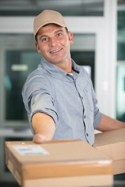 Happy Delivery Man Giving Parcel Camera — Stockfoto