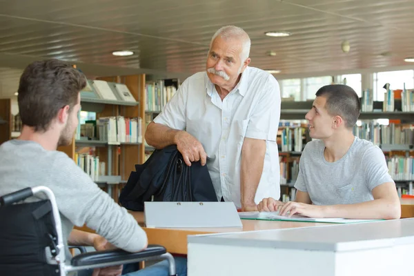 Два Студента Читают Библиотеке Старшим Преподавателем — стоковое фото