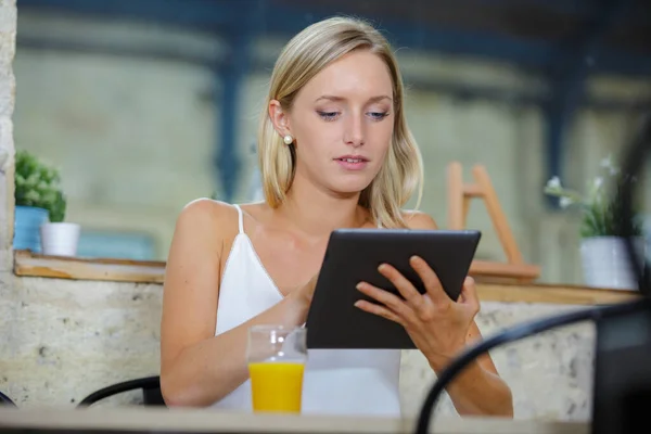 在酒吧里用平板电脑的年轻女人 — 图库照片