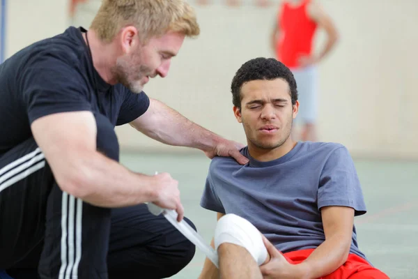 Physio Bandaging Young Mans Knee Sports Injury — Fotografia de Stock