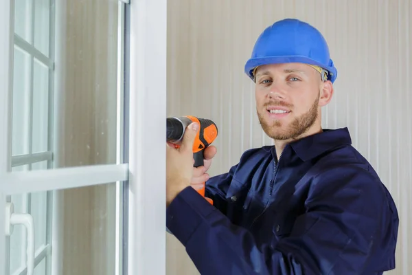 Happy Male Builder Uses Drill — Zdjęcie stockowe