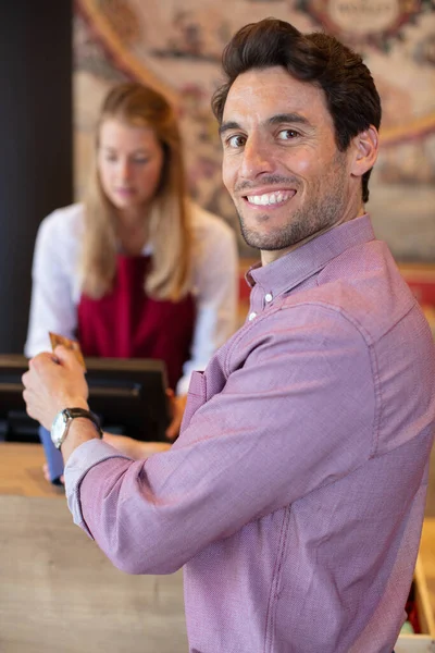wine steward taking credit card from male customer