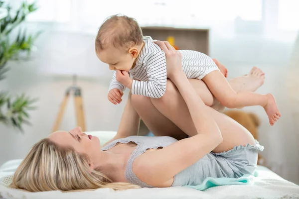 Young Mother Balancing Baby Her Legs — Stockfoto