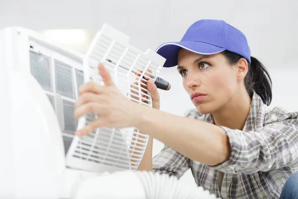 Female Worker Repairing Air Conditioner — Zdjęcie stockowe