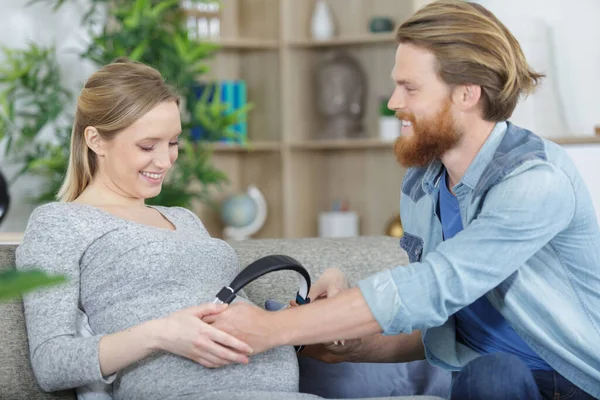 Pregnant Cwoman Husband Holding Headphones Tummy — Stok fotoğraf