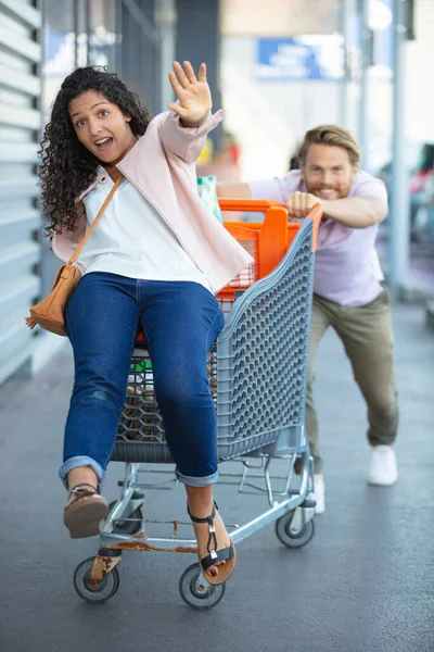 Young Happy Man Pushing Shopping Cart His Girfriend — Fotografia de Stock